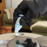 Testing a stainless steel cat food bowl for heavy metal purity using a blue chemical drop test on the metal surface.